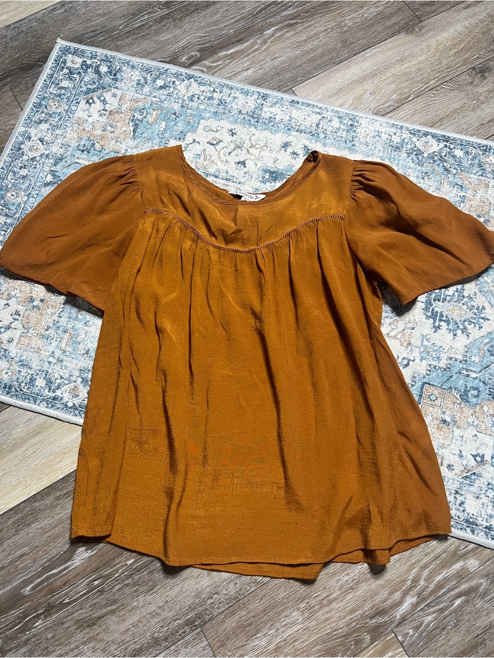 Nanette Lepore blouse is a burnt orange color with flutter sleeves